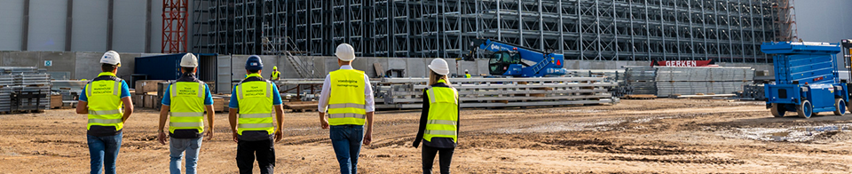 Gruppe von voestalpine Mitarbeiter:innen besichten die Hochregal-Anlage von außen